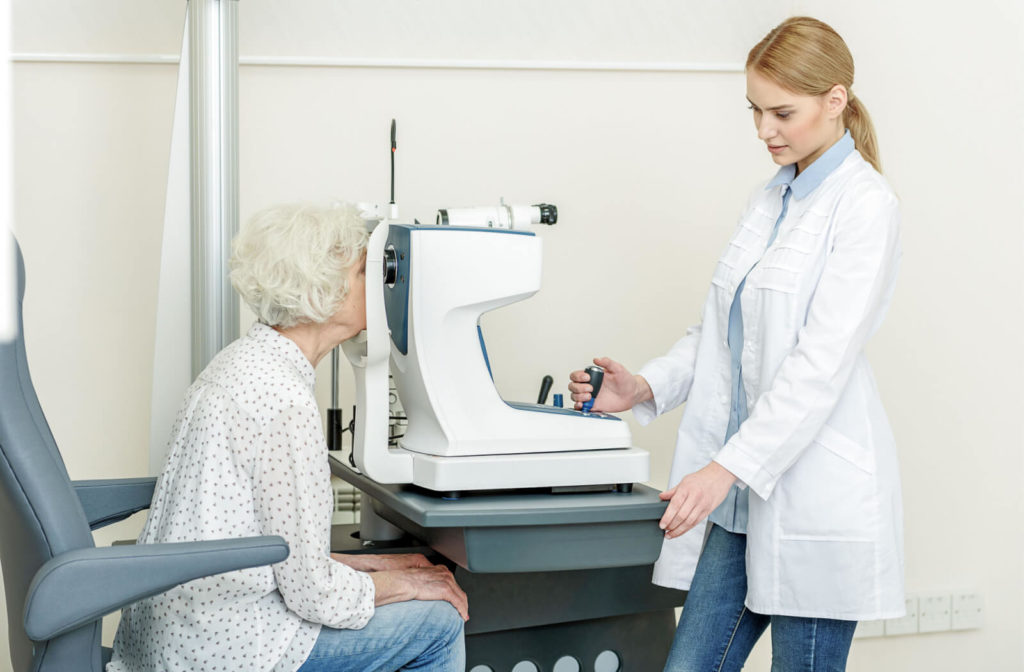 A female optician is scanning the eye of a senior woman with glaucoma with the use of a Tonometer to measure how well glaucoma treatment is working.