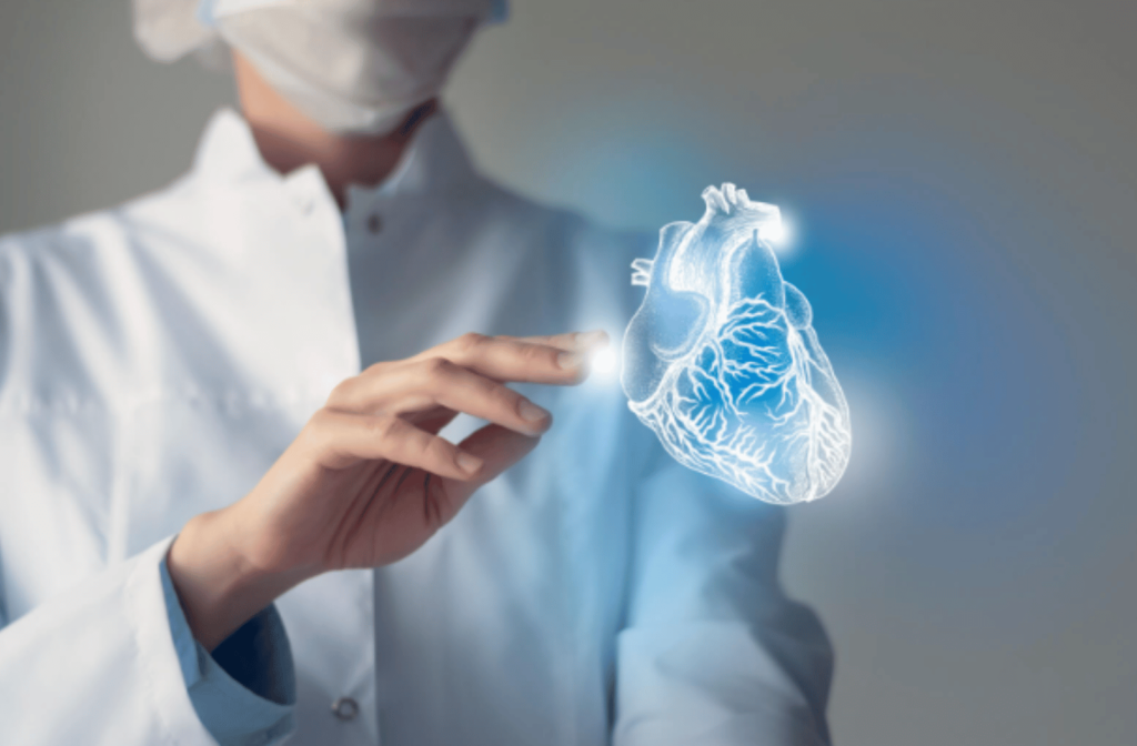 A female doctor is standing and her touching a virtual image of a heart. Optometrists can detect cardiovascular conditions such as clogged arteries and plaque deposits through an eye exam