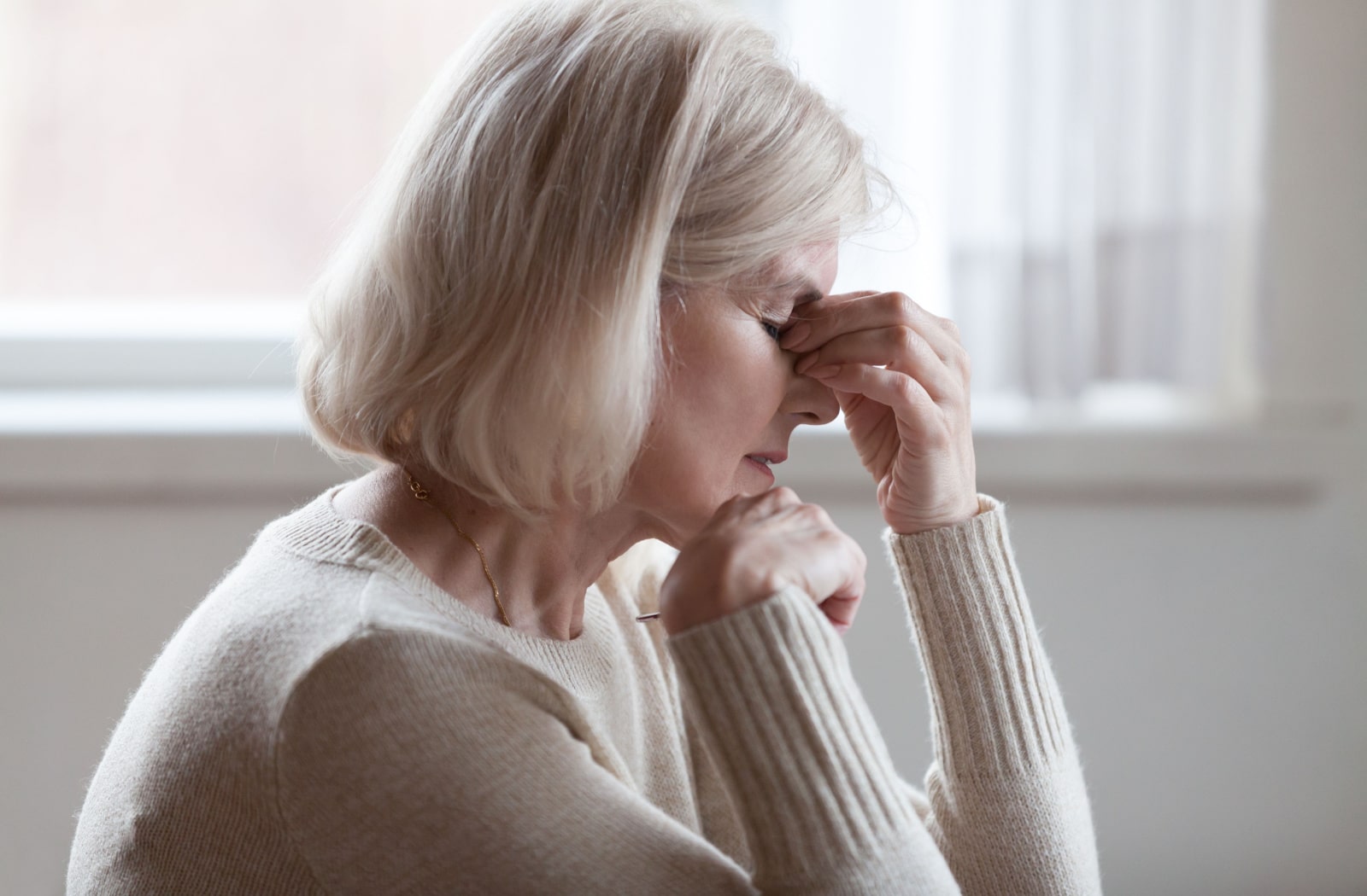 A senior woman is experiencing a severe headache due to developing Glaucoma