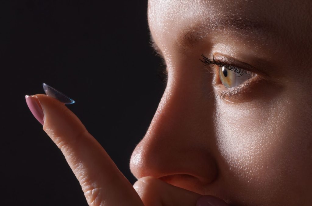 A close-up showing an individual applying their soft contact lens.